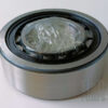 A metal roller bearing is lying on its side against a neutral white background.