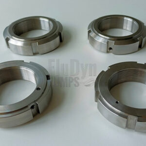 Four metal clamping nuts are arranged next to each other against a neutral white background. Two are on their upper side, the other two on the underside. On the outside you can see notches for tensioning and on the inside a recess for a groove.